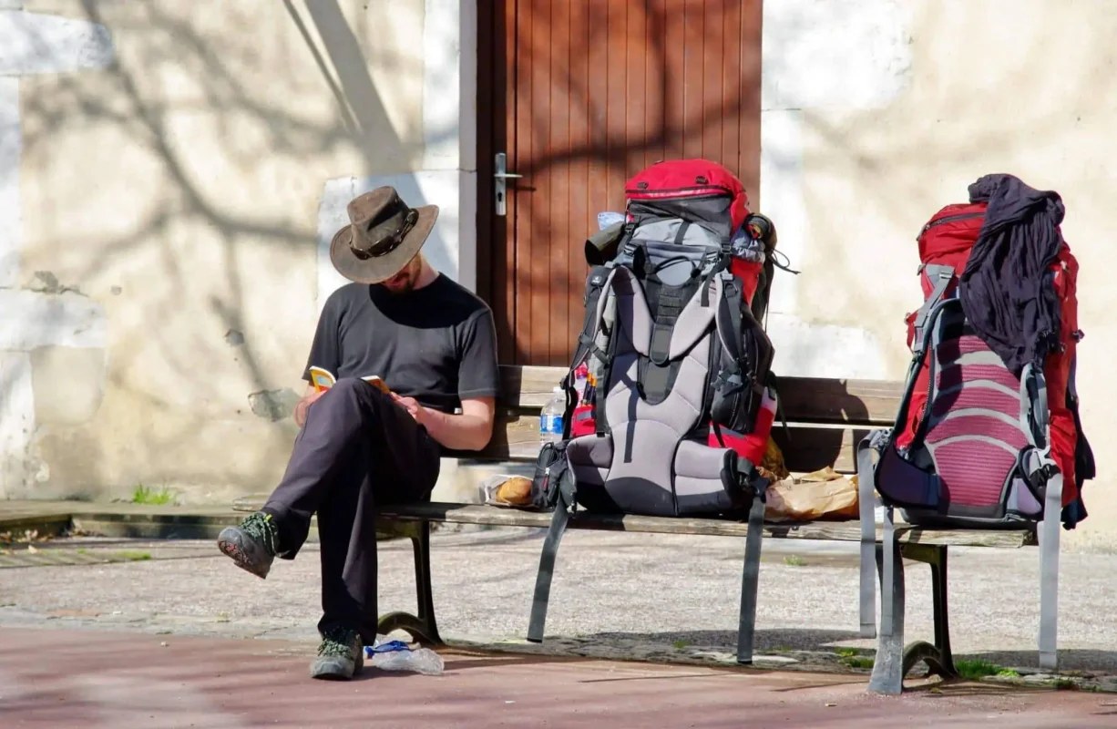 peregrino sentado num banco a escrever