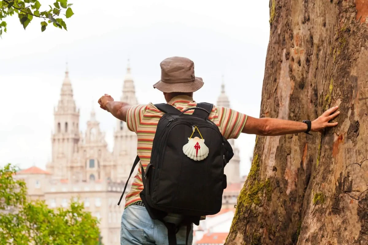 Peregrino a avistar a Catedral de Santiago ao fundo