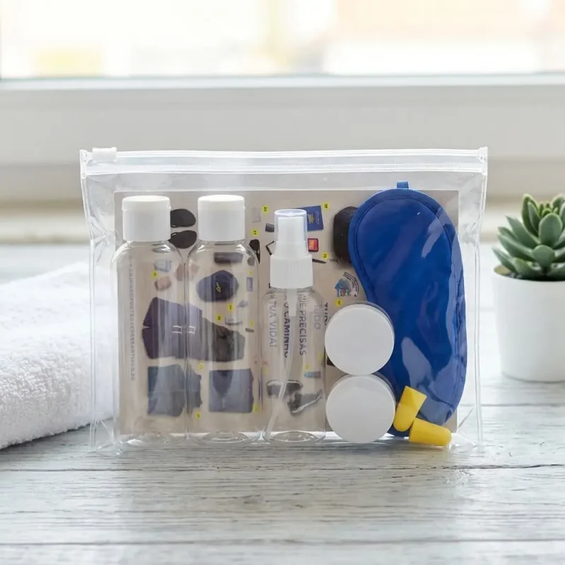 Plano aproximado do Necessaire Ultreya composto por duas embalagens de líquidos, duas caixinhas pequenas, uma venda para os olhos, os tampões para os ouvidos, e o postal checklist